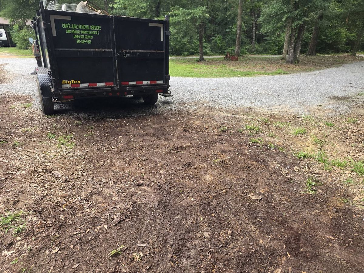 The same gravel driveway swept clean, with the loaded Cain's trailer ready to pull out.